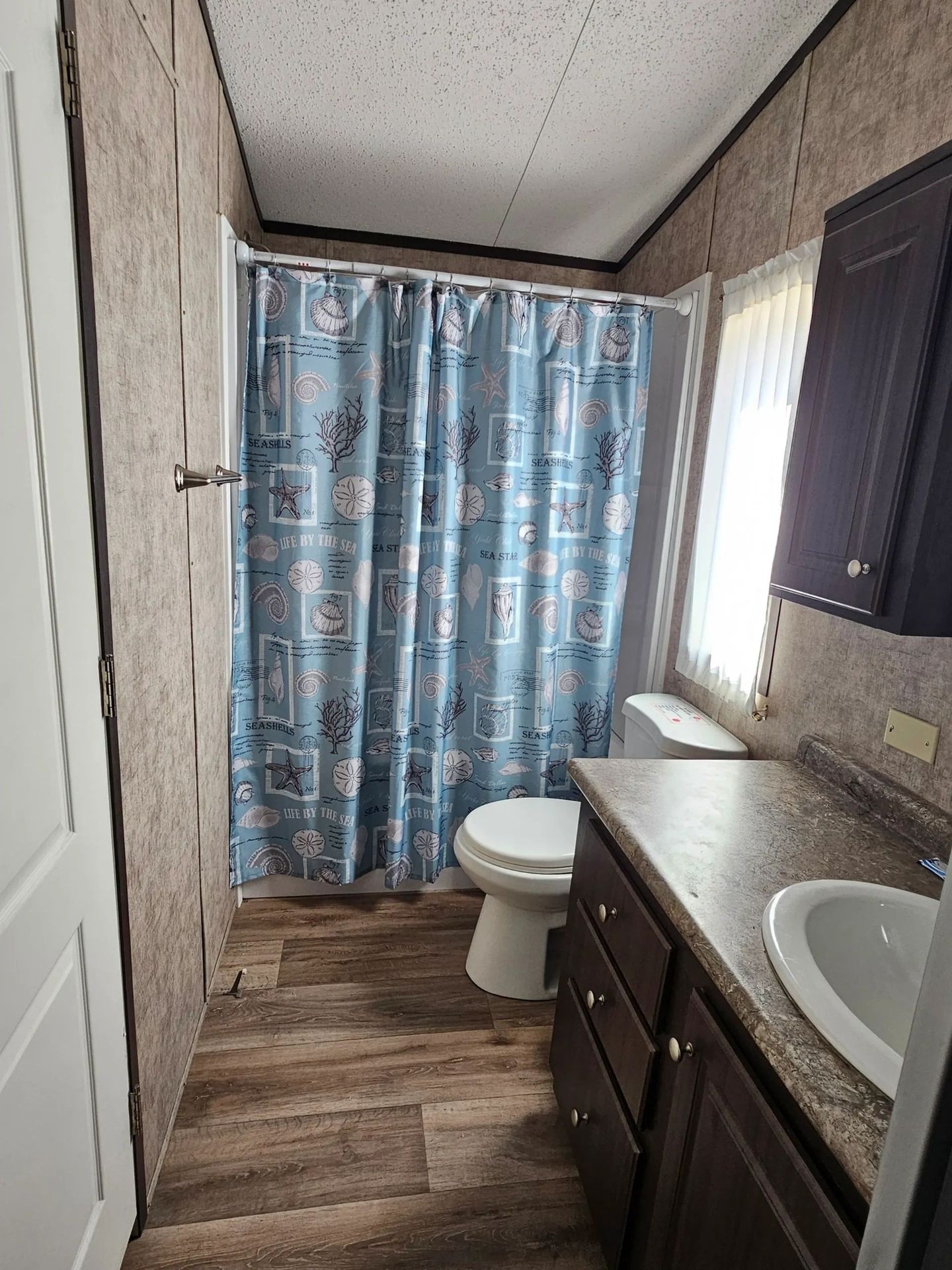 Tiny cabin bathroom with a shower, toilet and vanity.