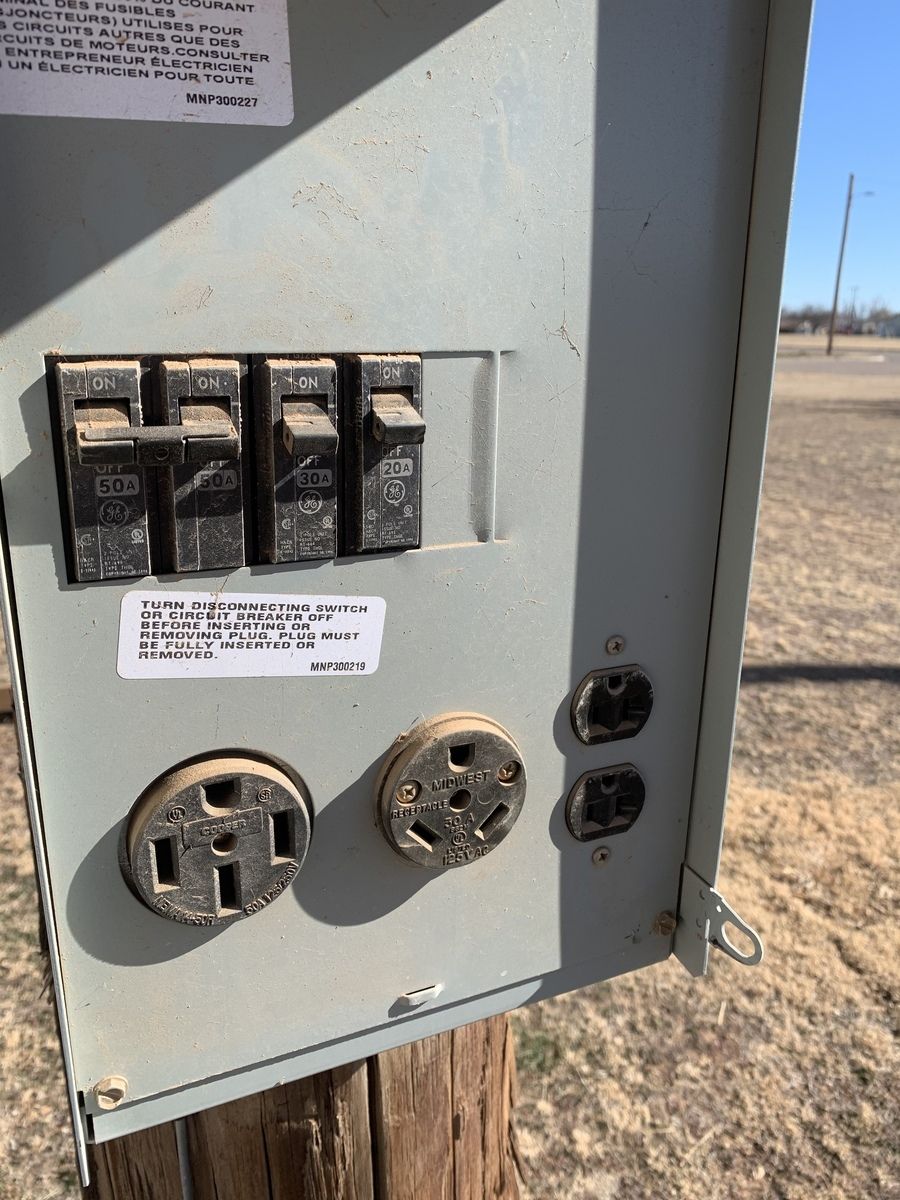 Electrical pedestal at an RV site with 50-amp, 30-amp and 20-amp outlets.