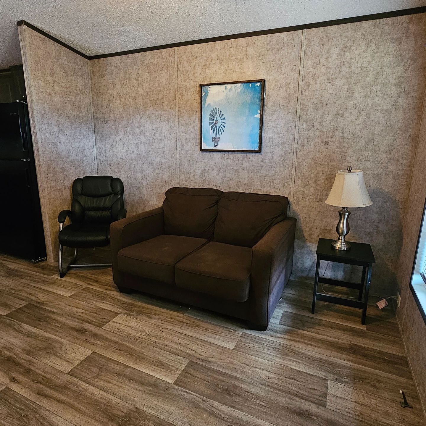 Tiny cabin sitting area with a loveseat, an armchair and a lamp.